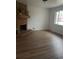 Bright living room with a brick fireplace, hardwood floors, and a large window at 5640 E 67Th Pl, Commerce City, CO 80022