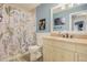 Well-lit bathroom featuring a floral shower curtain, white vanity, granite countertop, and coordinated wall art at 8975 S Coyote St, Highlands Ranch, CO 80126