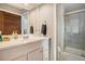 Bright bathroom featuring a vanity with a sink, and a glass-enclosed shower at 8975 S Coyote St, Highlands Ranch, CO 80126