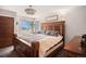 Cozy bedroom featuring a queen-size bed, wood-paneled walls, and a bedside table at 8975 S Coyote St, Highlands Ranch, CO 80126