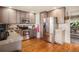 Updated kitchen with stainless steel appliances, granite countertops, and wood flooring at 8975 S Coyote St, Highlands Ranch, CO 80126