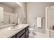 Neutral bathroom featuring a shower, toilet, sink, mirror, and tile floors at 785 Iris St, Brighton, CO 80601