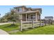Charming home featuring a classic wooden fence, lush green lawn, and inviting front porch at 785 Iris St, Brighton, CO 80601