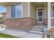 Inviting front entry featuring brick accents, smart home system, and a charming gnome at 785 Iris St, Brighton, CO 80601