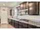 Beautiful kitchen featuring dark cabinets, granite countertops, and stainless steel appliances at 785 Iris St, Brighton, CO 80601