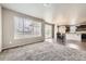 Spacious living room with carpet, a large window, and views into the kitchen and dining area at 785 Iris St, Brighton, CO 80601