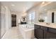 Bright bathroom with double sinks, soaking tub, walk-in shower, and a view from the bright sunny window at 785 Iris St, Brighton, CO 80601