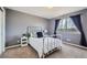 Cozy bedroom with white metal frame bed and window with dark blue curtains at 1045 English Sparrow Trl, Highlands Ranch, CO 80129