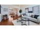 Sunlit living room with hardwood floors, modern decor, and an open view to a formal dining area at 1045 English Sparrow Trl, Highlands Ranch, CO 80129