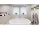 Bathroom featuring a soaking tub, tile surround, and a view from the windows at 1582 Fairfax St, Denver, CO 80220