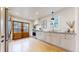 Bright kitchen with hardwood floors, stainless steel appliances, white cabinets, and a unique door leading outside at 1582 Fairfax St, Denver, CO 80220