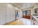 Well-lit kitchen featuring hardwood floors, stainless steel refrigerator, white cabinets, and a door leading outside at 1582 Fairfax St, Denver, CO 80220