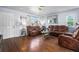 Cozy living room featuring hardwood floors, comfortable leather seating, and ample natural light, ideal for relaxation and entertaining at 4528 Andes St, Denver, CO 80249