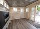 Cozy room boasts stylish tin ceiling, wood-look vinyl walls, wood floors, and modern electric fireplace at 17973 E Iowa Dr, Aurora, CO 80017