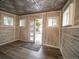 Charming room with unique metal patterned ceiling, wood-look vinyl walls, and wood-style floors at 17973 E Iowa Dr, Aurora, CO 80017
