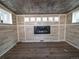 Inviting room featuring tin ceiling, wood-look vinyl walls, modern electric fireplace, and wood-style floors at 17973 E Iowa Dr, Aurora, CO 80017