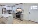 Modern kitchen with gray cabinets, island, and stainless steel appliances at 621 Campo St, Denver, CO 80221