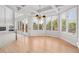 Sunlit dining area features hardwood floors, a modern chandelier and large windows with wooded views at 96 Falcon Hills Dr, Highlands Ranch, CO 80126