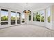 Bright dining room with tray ceiling, chandelier, large windows, and doors to the outdoor deck at 96 Falcon Hills Dr, Highlands Ranch, CO 80126