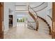 Elegant foyer with a curved staircase, tile flooring, and views into other rooms at 96 Falcon Hills Dr, Highlands Ranch, CO 80126