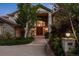 Elegant stone home featuring a grand entrance with double doors and manicured landscaping at 96 Falcon Hills Dr, Highlands Ranch, CO 80126