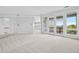 Spacious living room featuring neutral carpet, white walls, and glass doors to an outdoor balcony at 96 Falcon Hills Dr, Highlands Ranch, CO 80126