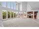 Spacious living room with floor-to-ceiling windows, a wet bar, and access to outdoor balconies at 96 Falcon Hills Dr, Highlands Ranch, CO 80126