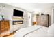 Bright bedroom with a modern fireplace, TV, and view to the bathroom at 4200 W 17Th Ave # 611, Denver, CO 80204