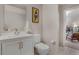 Bathroom with white sink and toilet with a framed piece of art and doorway to another room at 410 Acoma St # 515, Denver, CO 80204