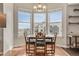 Sun-drenched dining area featuring hardwood floors, a chandelier, and bay windows with stunning city views at 410 Acoma St # 515, Denver, CO 80204