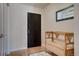 Neutral entryway featuring hardwood floors, coat rack, mirror, and wooden storage bench at 410 Acoma St # 515, Denver, CO 80204