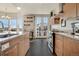 A bright kitchen with stainless steel appliances, wooden cabinets, bar and a stunning view of the city skyline at 410 Acoma St # 515, Denver, CO 80204