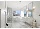 Bright bathroom features a soaking tub, dual vanities, and a glass enclosed shower with marble tiling at 6725 Beech Ct, Arvada, CO 80004