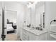 Elegant bathroom boasting a double vanity with marble countertops and modern fixtures, with a glimpse into the bedroom at 6725 Beech Ct, Arvada, CO 80004