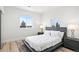 Sunlit bedroom with a contemporary bed, matching nightstands, and a scenic view from the double windows at 6725 Beech Ct, Arvada, CO 80004