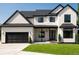 Striking two-story home featuring a modern design with a dark garage, black trim and complementary green lawn at 6725 Beech Ct, Arvada, CO 80004