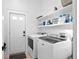 Bright laundry room with modern washer, dryer, shelving, and exterior door at 6725 Beech Ct, Arvada, CO 80004