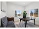 Bright home office with a large desk, a tufted bench, and natural light from the window at 6725 Beech Ct, Arvada, CO 80004