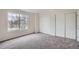 Carpeted bedroom with double closets and a large window with a neighborhood view at 19213 E Idaho Dr # 105, Aurora, CO 80017