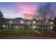 Exterior of a townhome complex at dusk with manicured lawns and mature trees at 19213 E Idaho Dr # 105, Aurora, CO 80017