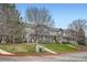 Exterior of a townhome complex featuring a lush lawn and various trees at 19213 E Idaho Dr # 105, Aurora, CO 80017