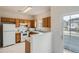 Functional kitchen with white appliances and wooden cabinets providing ample storage and workspace at 19213 E Idaho Dr # 105, Aurora, CO 80017