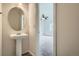 Pedestal sink in the powder room with tile floors, and a view of the carpeted bedroom beyond at 19213 E Idaho Dr # 105, Aurora, CO 80017