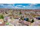 Aerial view of houses in the neighborhood surrounded by mature trees and a pond at 6882 Quail St, Arvada, CO 80004