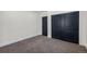 Cozy bedroom with plush carpeting and closet with dark blue doors at 6882 Quail St, Arvada, CO 80004