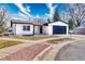 Charming single-story home features stucco and stone accents, a well-manicured lawn, and a spacious two-car garage at 6882 Quail St, Arvada, CO 80004