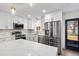 Modern kitchen with white cabinets, stainless steel appliances, and a marble countertop island at 6882 Quail St, Arvada, CO 80004