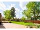 Large backyard with a brick patio, mature trees, a storage shed, and lush green lawn at 11131 W Oregon Pl, Lakewood, CO 80232