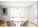 Bright dining area features a modern chandelier, marble table, natural light from a nearby window, and hardwood floors at 11131 W Oregon Pl, Lakewood, CO 80232