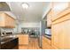 Open concept kitchen that features wood cabinets, hardwood flooring, and a stainless steel fridge at 11131 W Oregon Pl, Lakewood, CO 80232